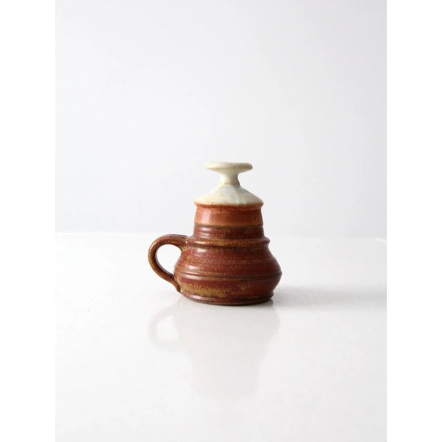 A vintage studio pottery oil lamp by artist Charles Piatt. The wheel thrown pottery features a beautiful ridged shape with...