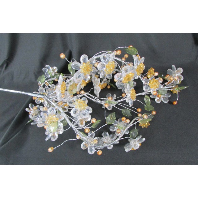 Consisting of threading of transparent, yellow, orange and green beads in the shape of faceted balls, flowers and leaves....