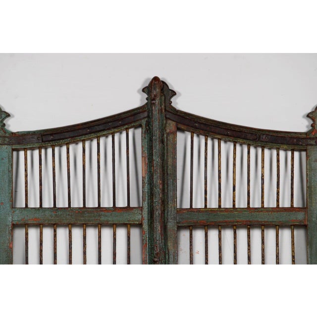 Vintage Indian Painted "Dog Door" or Gate, with a curved top, shaped center and side finials, and iron security rods. It...