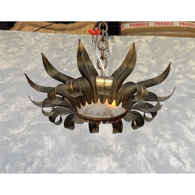 This striking mid-century Spanish ceiling fixture features a sculptural sunburst design with alternating tiers of hand-...
