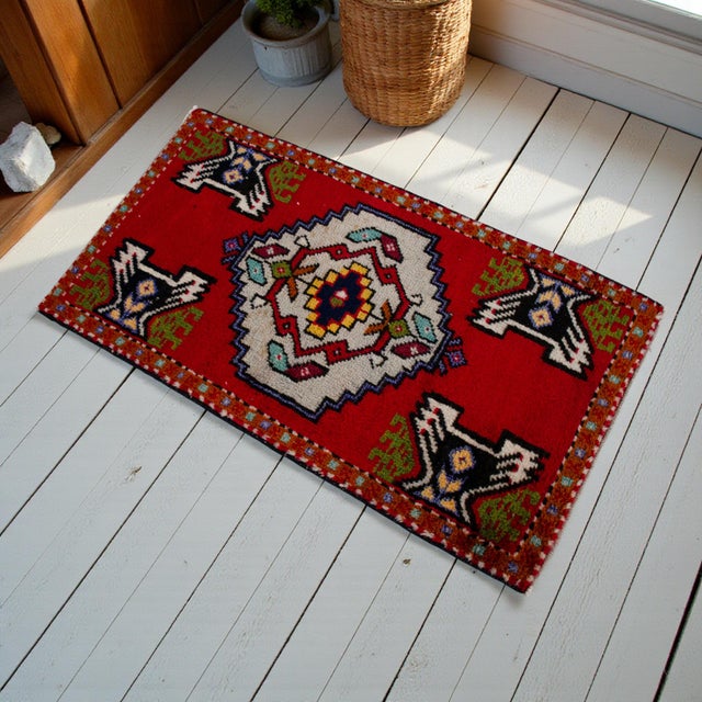 This charming hand-knotted Oushak rug features a vibrant crimson field anchored by a striking geometric central medallion....