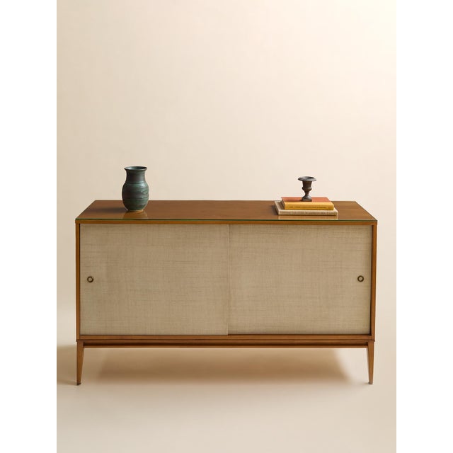 A sophisticated sideboard from Paul McCobb’s Planner Group "Winchester" line, featuring a clean architectural frame and...