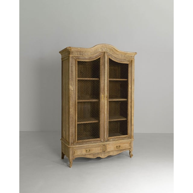 This early 1900s French Louis XVstyle oak vitrine exemplifies the graceful curves and refined ornamentation associated...