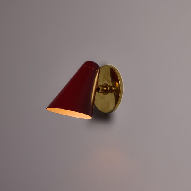 Pair of 1960s Stilnovo Perforated Red Metal and Brass Articulating Sconces Executed in painted perforated metal shade with...