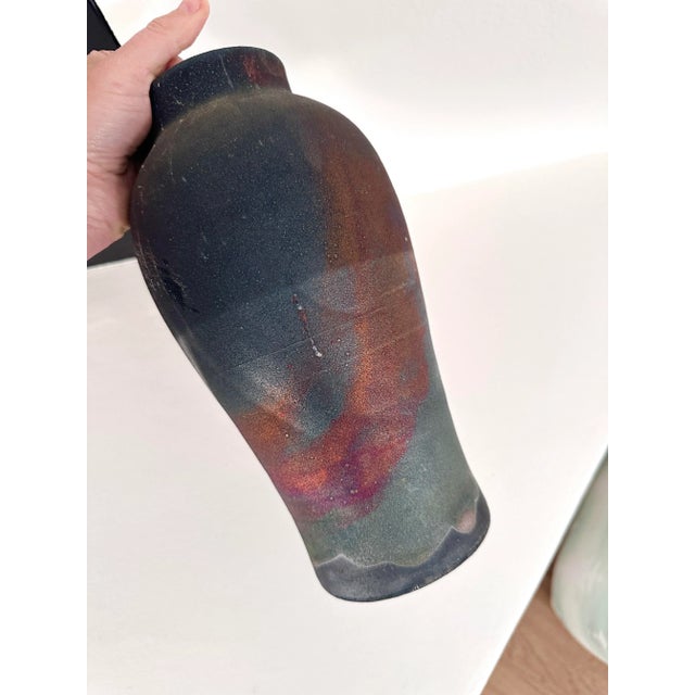 Striking artisan raku pottery vase with a sleek, modern silhouette and beautifully varied colors. The raku firing process...