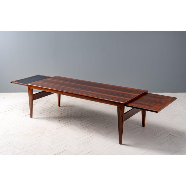 Denmark, ca. 1960s. An elegant yet substantial rosewood coffee table by Johannes Andersen. Features rosewood construction...