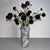 Handcrafted from richly veined white marble, the Array Tall Vase is defined by its elongated silhouette and rhythmic...