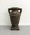 Architectural ceramic urn featuring a substantial handled silhouette with raised geometric banding and a richly textured...