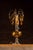 Hollywood Regency table lamp featuring a sculptural amber glass font mounted on an ornate cast-metal base with a white...