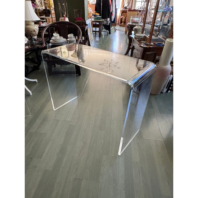 A stunning example of 1970s American modernism, this crystal-clear Lucite waterfall console table is a true single-piece...