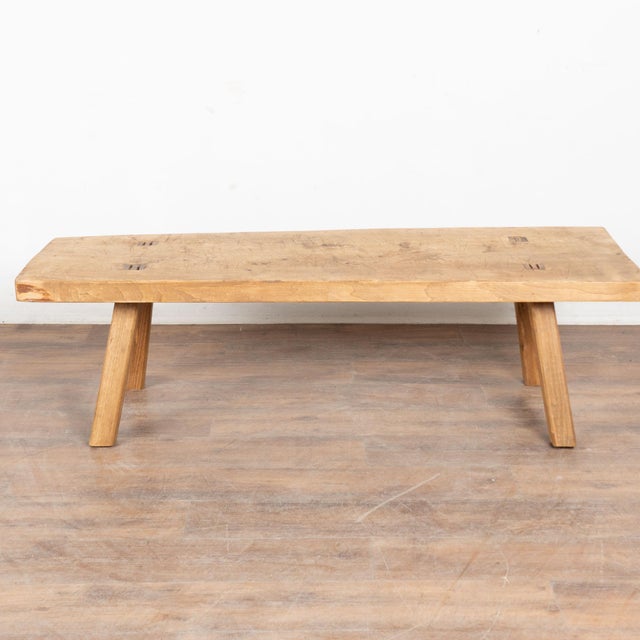 The appeal of this rustic coffee table comes from the thick wood of the top that originally served as a worktable. The...