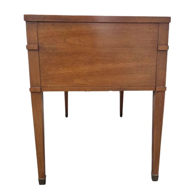 This is a vintage Sligh Lowry walnut writing desk with a gilded black leather top. It is in the Regency Revival style, and...