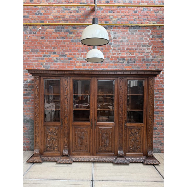 This monumental display cabinet made of solid oak has been fully restored. It features four doors with glass panels in the...
