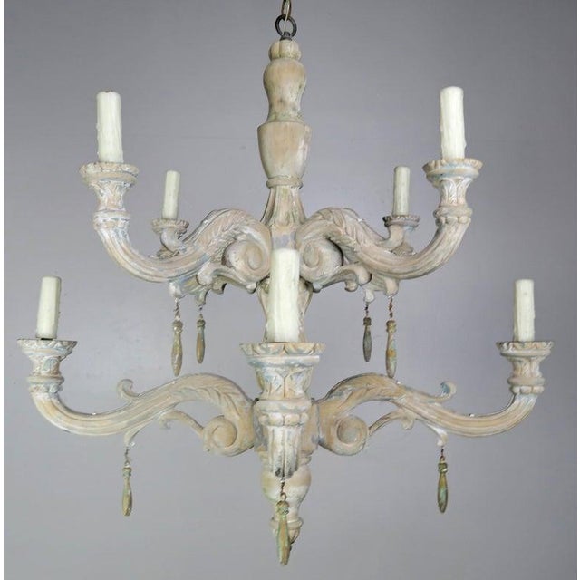 Eight-light Italian style carved wood two-tier chandelier with remnants of paint throughout. This fixture has a beautiful...