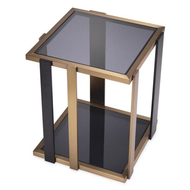 Contemporary square side table combining a geometric structure in stainless steel and iron with brushed brass and black...