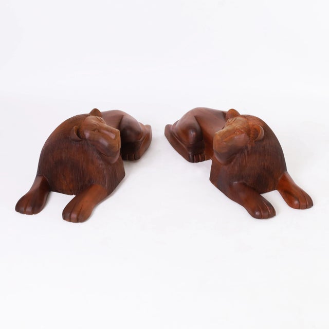Rare and remarkable pair of mid century lions in repose hand carved, in a stylized modern form, from the Cammatillo tree...