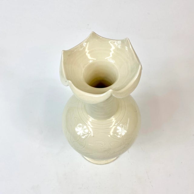 This is a 20th C Song- Style (960-1279) porcelain vase with a unique scalloped top and a floral decoration around the body