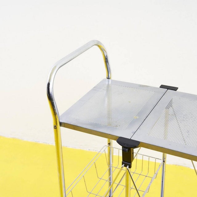 Discover this charming metal serving cart dating back to the 1960s. This designer piece features a lightweight yet sturdy...