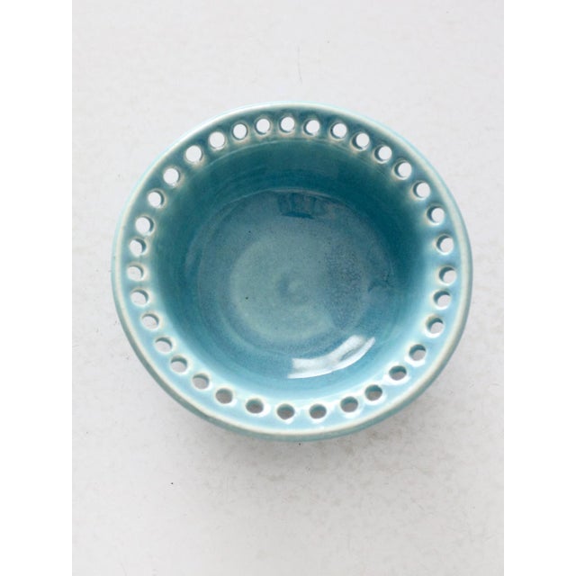 This vintage studio pottery bowl is finished in a bright turquoise glaze and signed by the artist. The rim features a band...