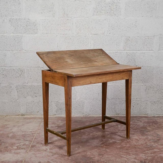 This folding writing table, dating back to the early 20th century, reflects the understated functionality typical of...