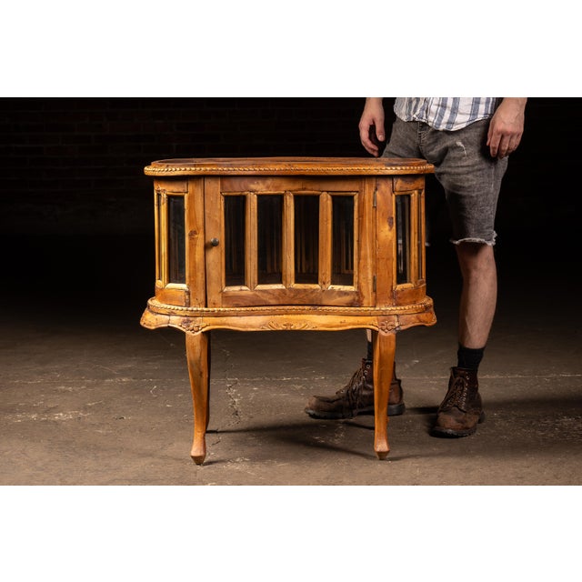 Serpentine-front tabletop curio cabinet raised on cabriole legs with carved apron detailing and beaded molding surrounding...