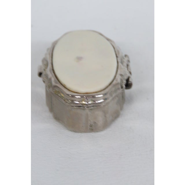 This lovely Lidded Pill Box is made of metal and features a cream-colored oval decorating the top of the lid. This...