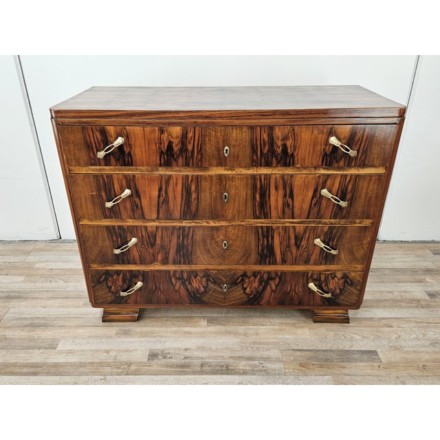 Elegant Art Deco chest of drawers covered in briar with brass hardware and four large and sturdy drawers. The piece of...