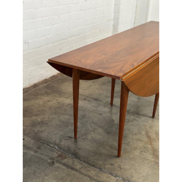 W72.5 D22 D48 H28.25 KC27 Vintage drop leaf dining table attributed to Edward Wormely for Dunbar. Item is structurally...