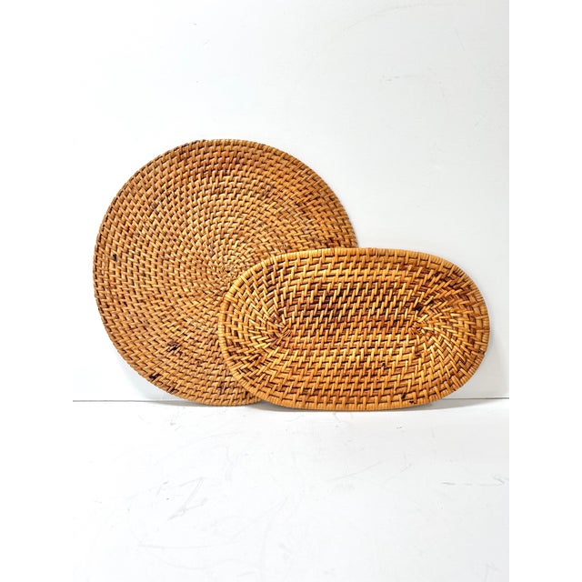 A warm and textural set of two vintage woven rattan trivets, featuring classic basketweave construction in complementary...