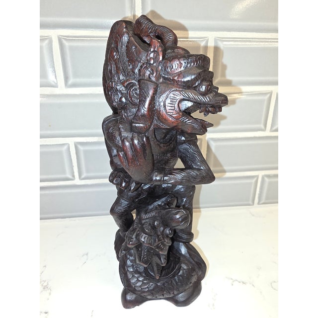 An exceptional, highly dynamic mid-century Balinese mythological sculpture depicting the divine eagle king, Garuda, in...