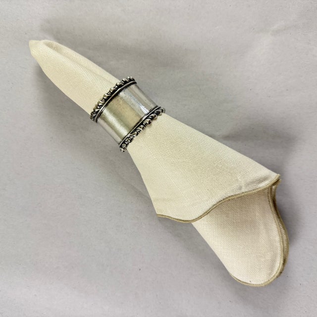 A heavy wide, round sterling silver scroll banded napkin ring, circa 1900-1920. Substantial banding at top and bottom, no...