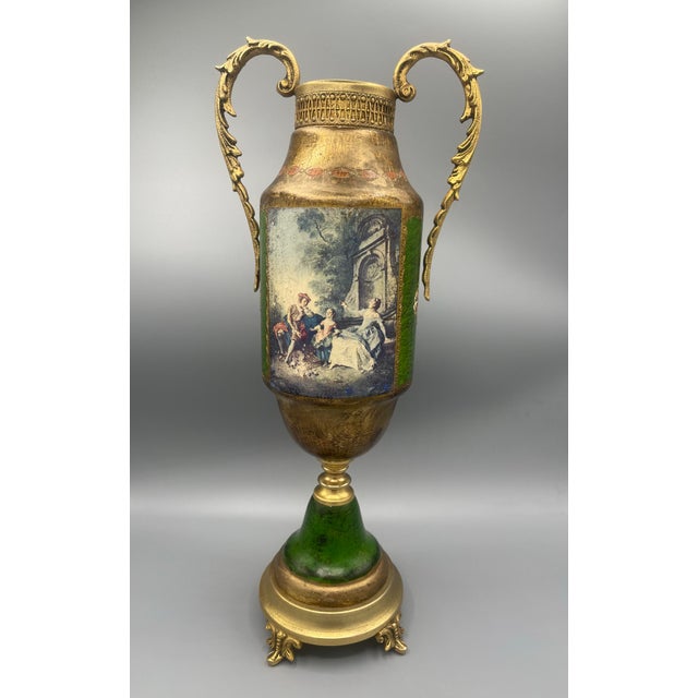 Elegant vintage decorative urn featuring rich green panels, ornate gold-tone detailing, and classical figural scenes. The...