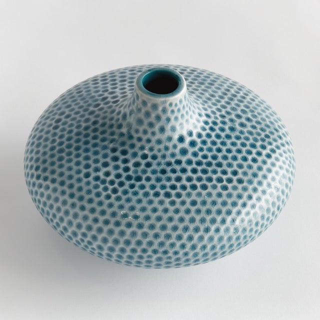 A narrow opening, reactive glaze and highly textured organic dot pattern, this decorative vase is a true work of art. A...