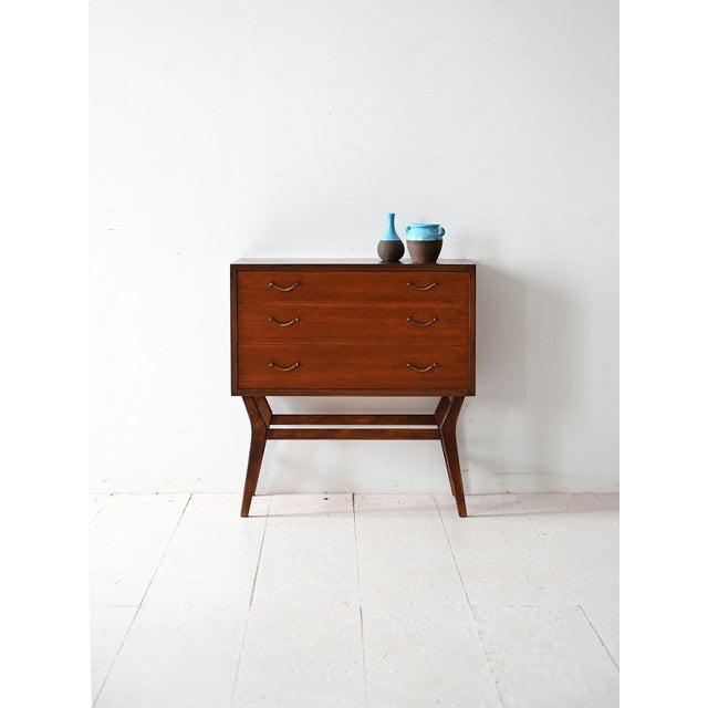 Vintage mahogany chest of drawers with three drawers, metal handles and tapered legs. Clean lines and refined details....