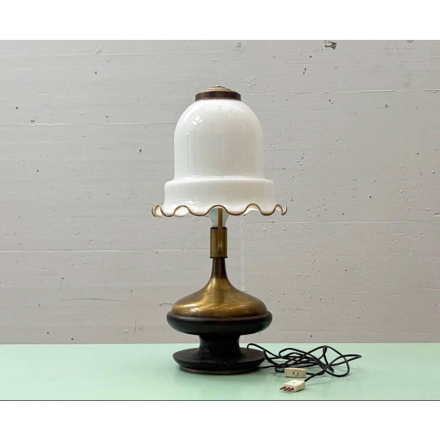 A striking Italian table lamp from the 1920s, featuring a handcrafted Murano glass shade with a characteristic, softly...