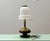 A striking Italian table lamp from the 1920s, featuring a handcrafted Murano glass shade with a characteristic, softly...