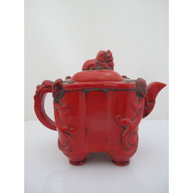 Chinese red lacquer molded teapot, inspired by Ming Dynasty designs. Striking red tone lacquer. Footed teapot with lid and...