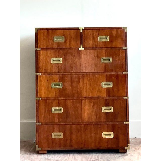 Embrace timeless sophistication with this exquisite vintage campaign tallboy chest by the celebrated American maker,...