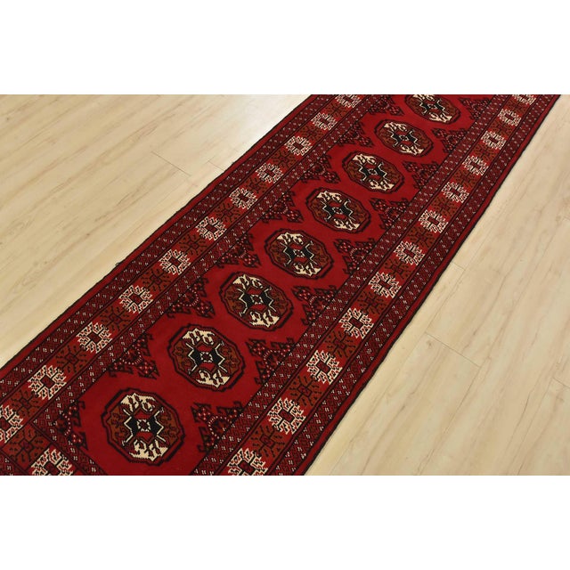 An authentic vintage tribal Turkmen runner, hand-knotted with fine wool and natural dyes. This nomadic rug features a row...