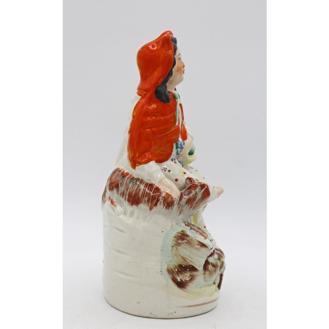 Circa 1860-80 Staffordshire Little Red Riding Hood figure, English. She carries her basket with her dog by her side off to...