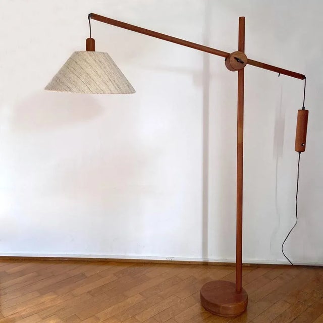 Tall Danish Mid-Century Modern floor lamp, produced around the early 1970's. The teak frame has an adjustable arm (with a...