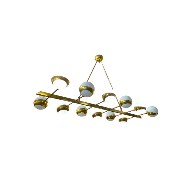 A stunning Italian lamp from the 1970s with a large brass body and glass spheres. Its horizontal metal structure consists...