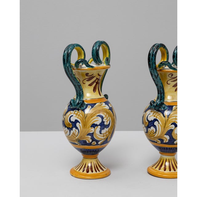 This pair of 20th Century Italian painted ceramic vases showcases the vibrant artistry and classical influences...