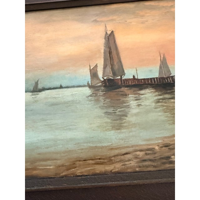An atmospheric antique harbor scene rendered in oil on canvas, depicting sailboats resting quietly beside a rustic...