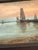 An atmospheric antique harbor scene rendered in oil on canvas, depicting sailboats resting quietly beside a rustic...