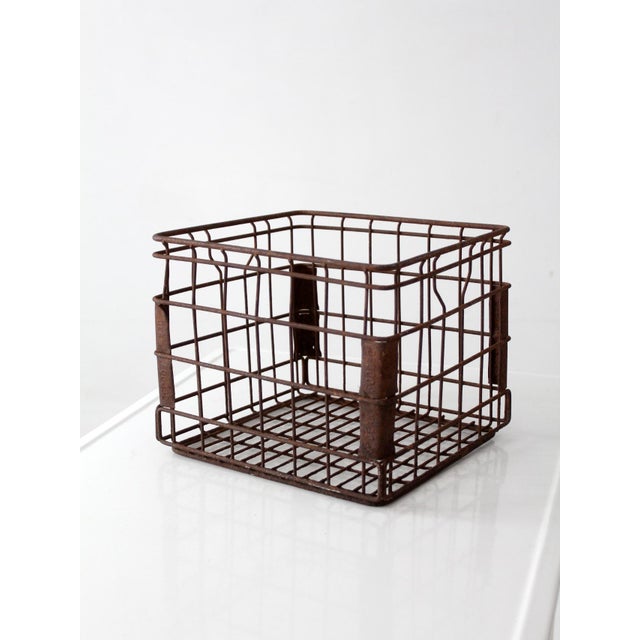 A vintage Dean Foods milk crate featuring striking wire construction and a beautifully aged patina. Embossed Dean Foods...