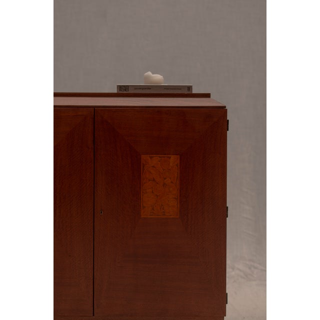 Elegant French Art Deco cabinet dating from the 1940s, featuring a refined geometric silhouette softened by warm wood...