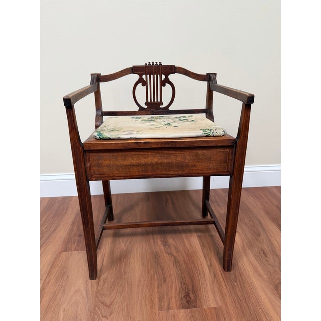 Antique Edwardian piano stool in mahogany with inlaid detailing and a classic lyre-form back, offering an authentic period...