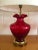 Stunning pair of Hollywood regency style table lamps with brass Asian-style base and red translucent glass core with...
