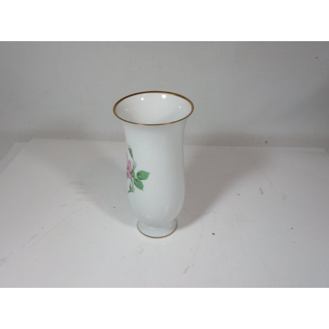 Hand-painted porcelain rose vase made by the A K Kaiser Co. in Germany. The vase has a gold trim around the flared top rim...
